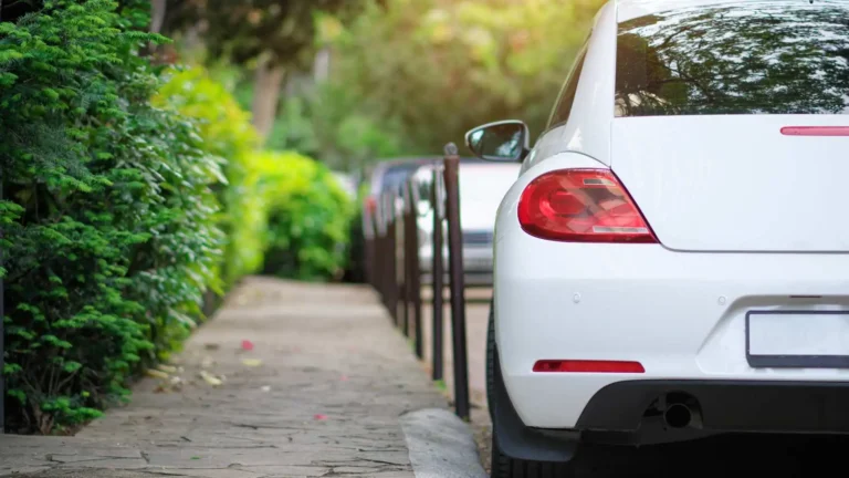 White car parked on roadside representing average cost of car insurance in Alaska